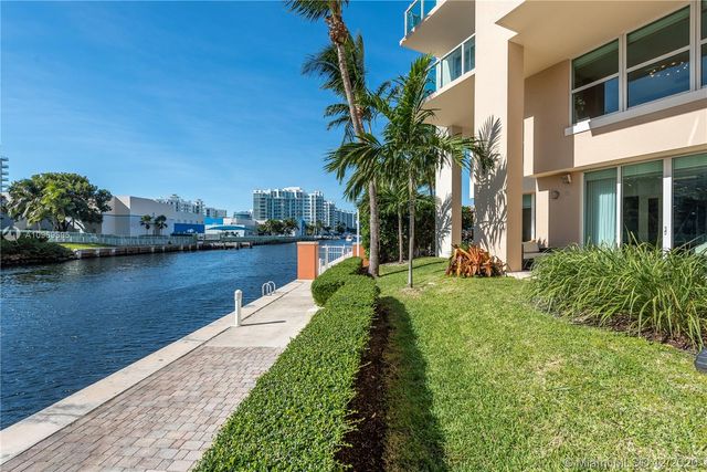 a view of a lake with a yard and large trees