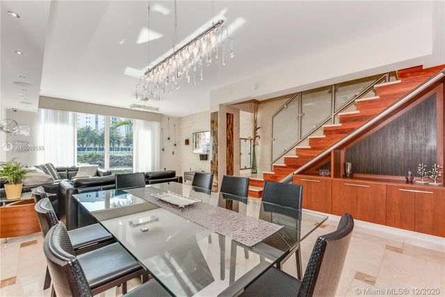 a living room with furniture a large window and wooden floor