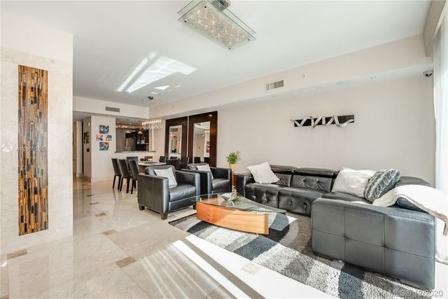a living room with furniture kitchen view and a window