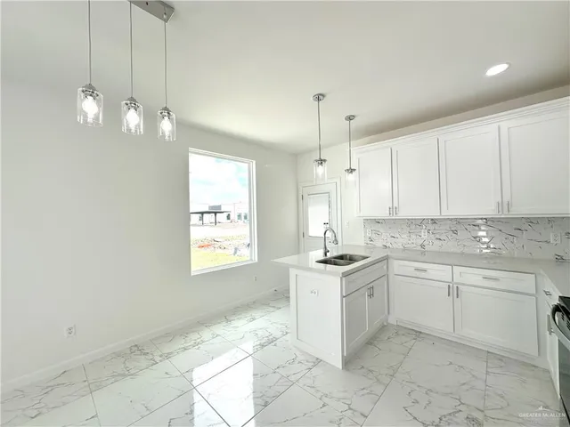 a kitchen with kitchen island a sink stainless steel appliances and cabinets