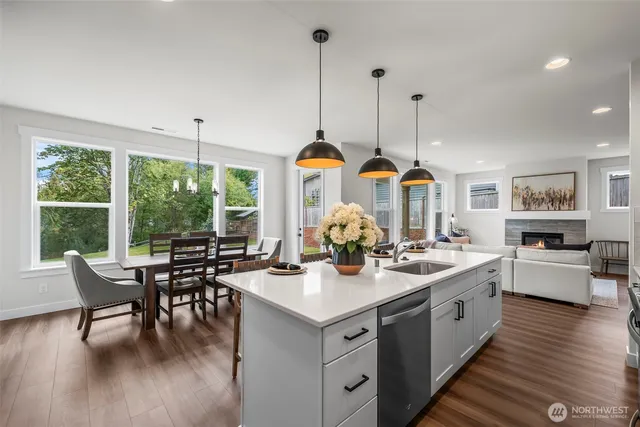 a view of a dining room and livingroom with furniture wooden floor a chandelier