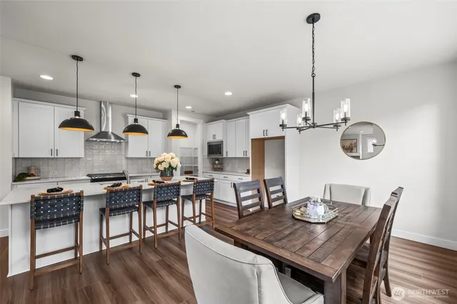 a view of a dining room with furniture a kitchen and chandelier