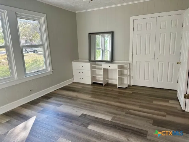 a view of a room with wooden floor and window