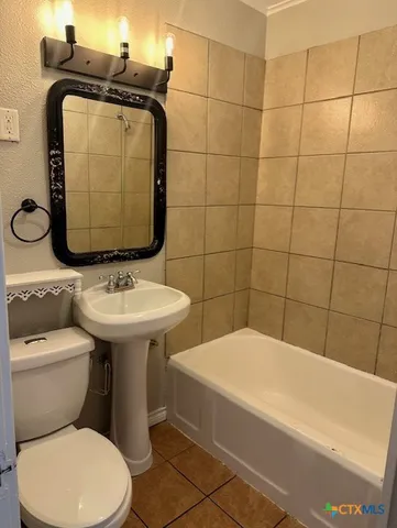 a bathroom with a sink toilet and mirror