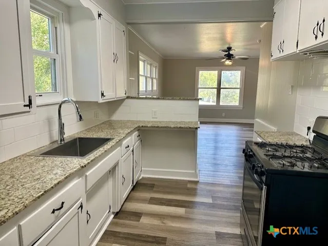 a kitchen with granite countertop a stove and a sink