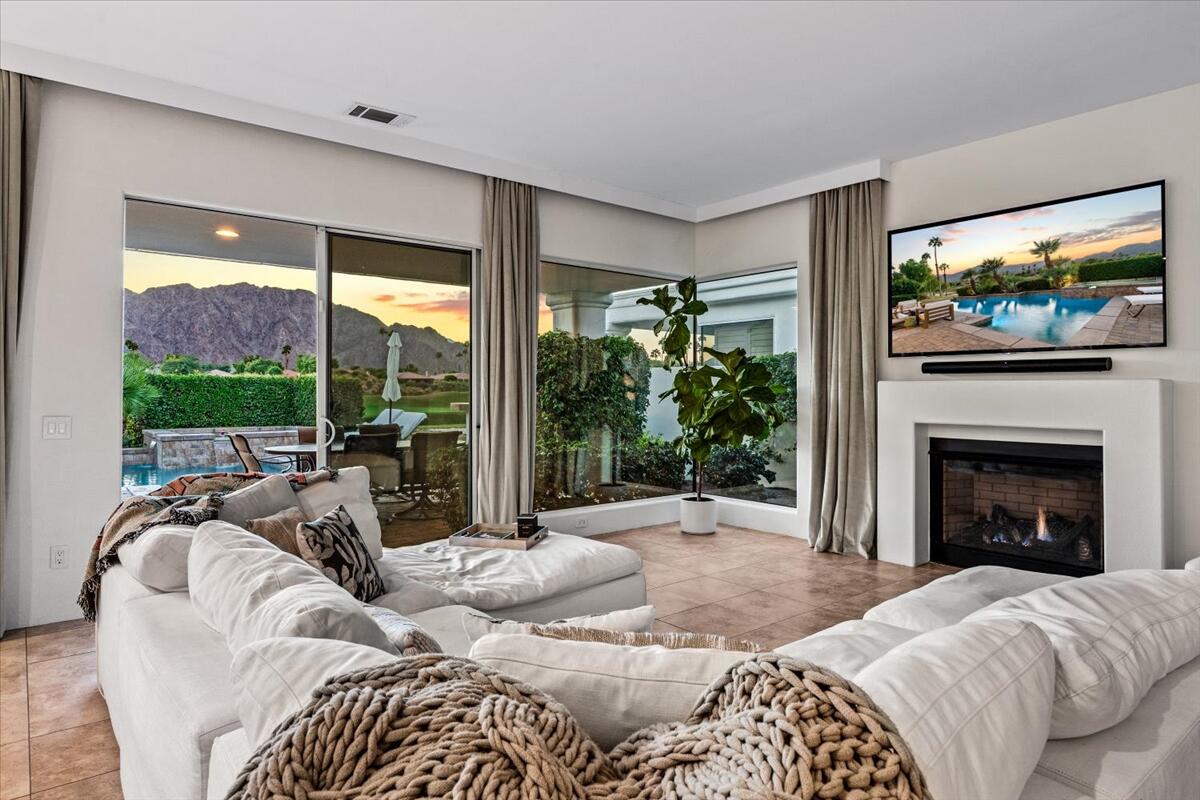 54695 Winged Foot La Quinta, CA 92253 - Photo 5 of 51 a bedroom with furniture a fireplace and a large window