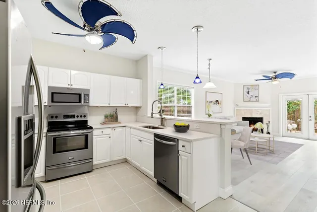 a kitchen with granite countertop a stove a sink and a refrigerator