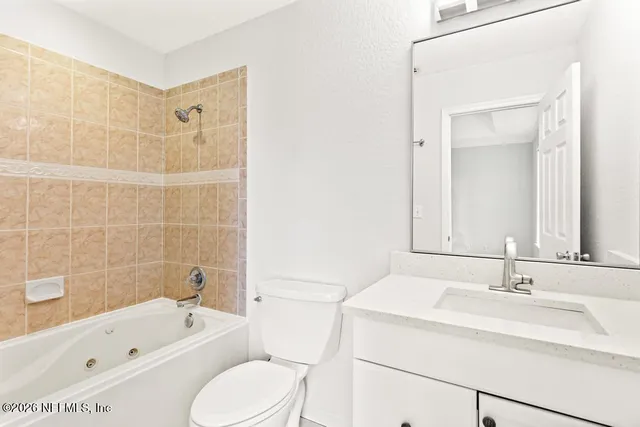 a bathroom with a granite countertop sink a toilet and a mirror
