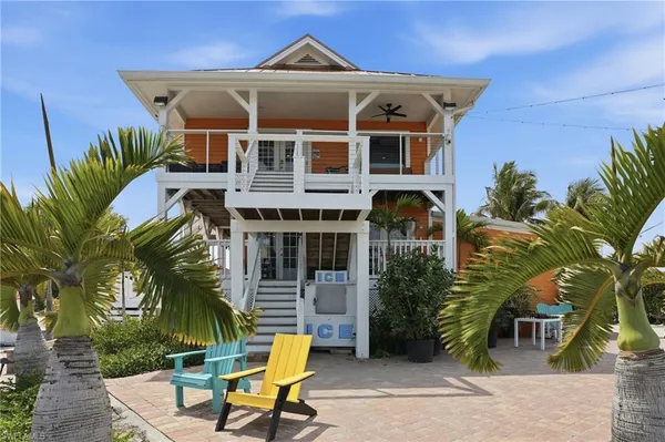an aerial view of a house with a yard and ocean view