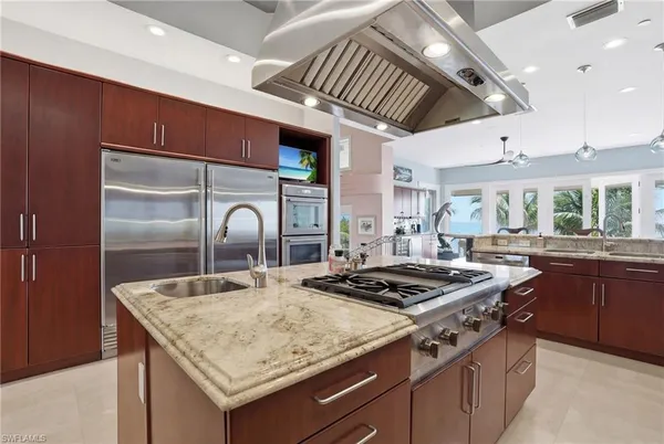 a kitchen with stainless steel appliances granite countertop a sink a stove and a wooden floors