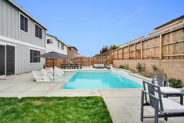 a backyard of a house with table and chairs
