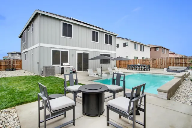 a view of a patio with couches table and chairs with plants and garden
