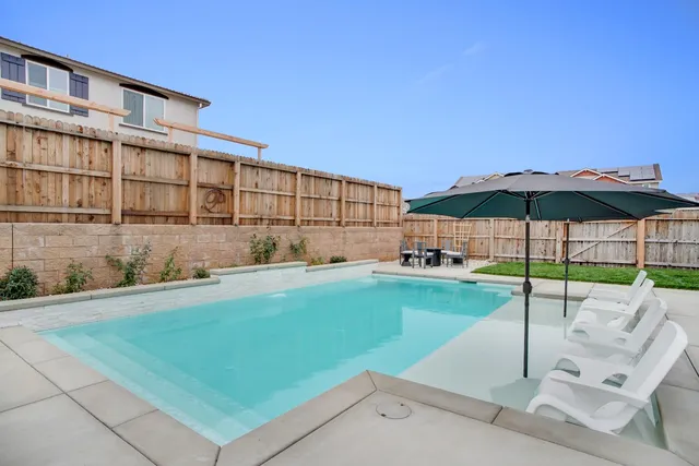 a view of a backyard with a garden and patio