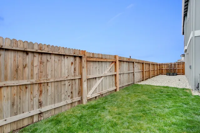 a view of a backyard with wooden fence