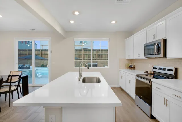 a kitchen with a sink a stove and cabinets
