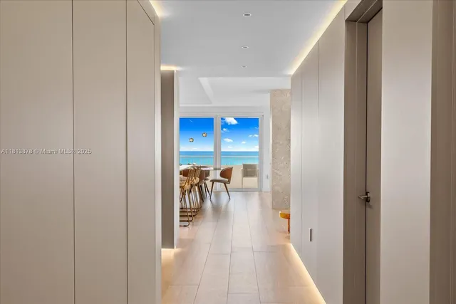 a view of a hallway with a dining room with chandelier