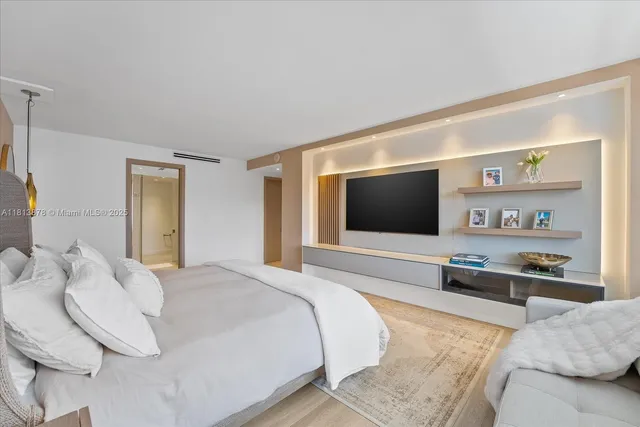 a spacious bedroom with a bed and a flat screen tv