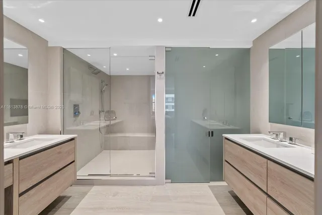 a bathroom with a double vanity sink mirror and shower