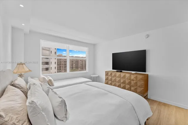 a bedroom with a bed and a flat screen tv