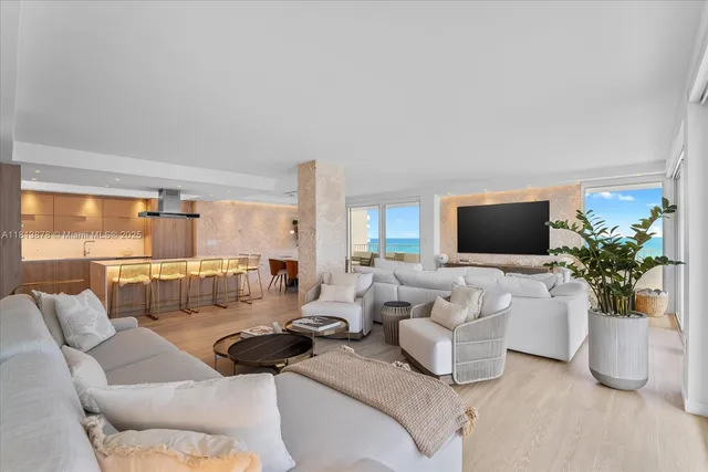 a living room with furniture a flat screen tv and a large window