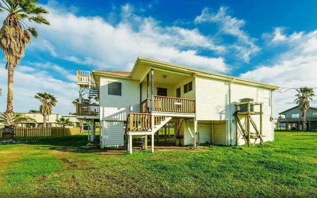 a view of a house with a big yard and potted plants
