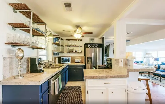 a kitchen with stainless steel appliances kitchen island granite countertop a sink and cabinets