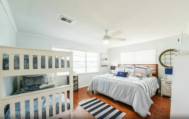 a bedroom with a bed a chandelier and dresser