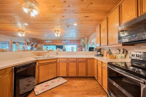 a kitchen with stainless steel appliances granite countertop a stove a sink and a microwave