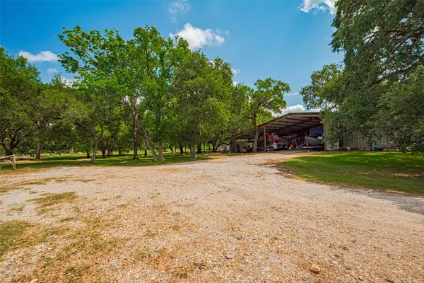 a view of a house with backyard and trees