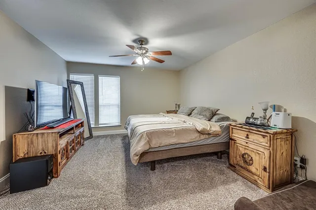 a spacious bedroom with a bed and a flat screen tv