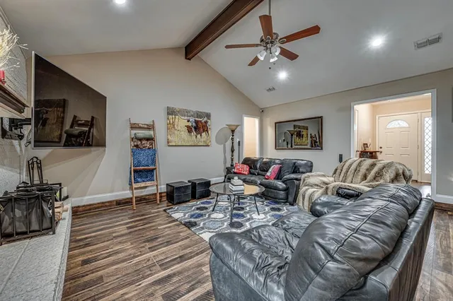a living room with furniture ceiling fan and a wooden floor