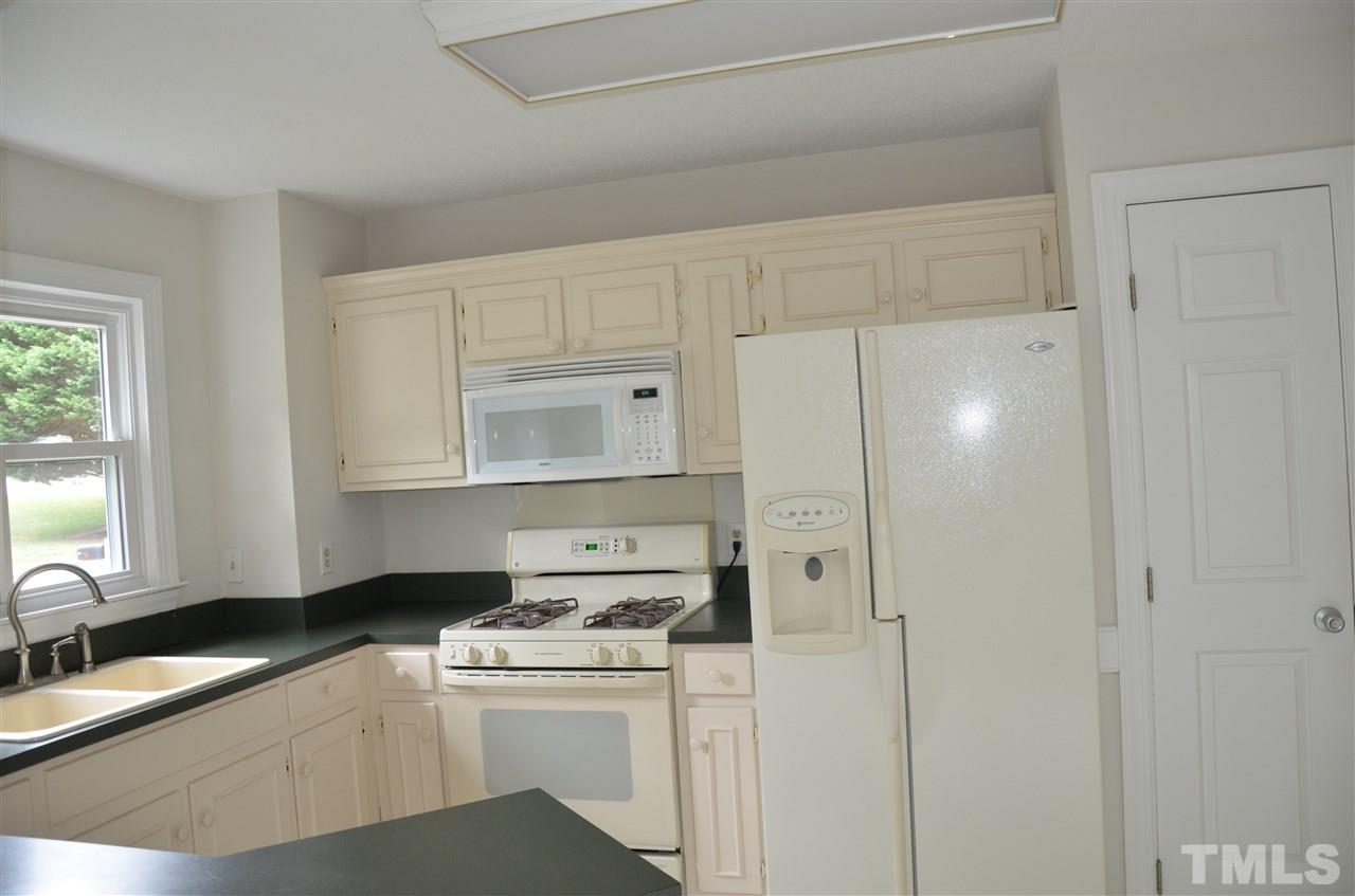 8816 Life Lane Raleigh, NC 27615 - Photo 11 of 25 a kitchen that has a sink a stove and a refrigerator