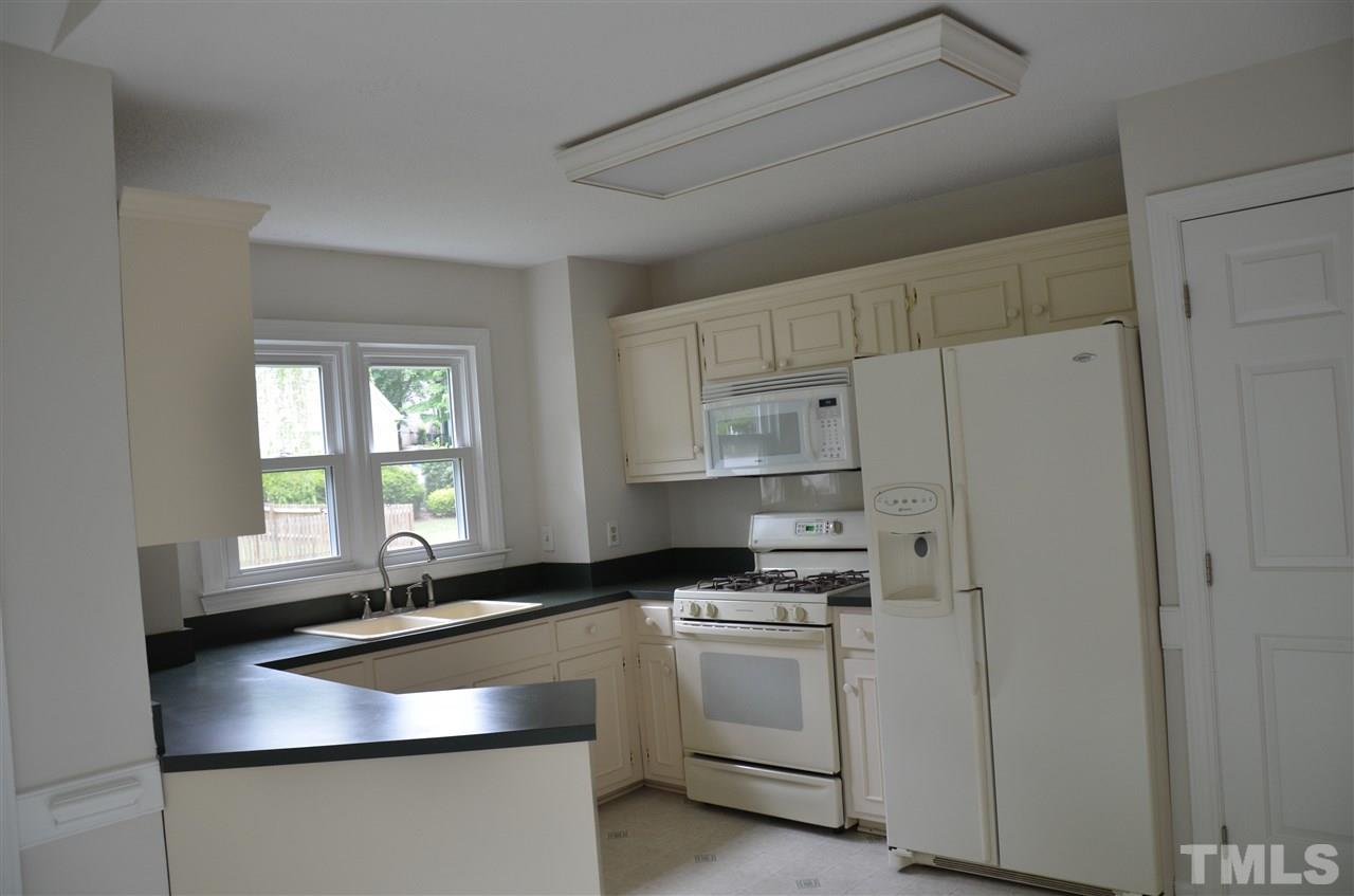 8816 Life Lane Raleigh, NC 27615 - Photo 10 of 25 a kitchen with granite countertop white cabinets and white appliances