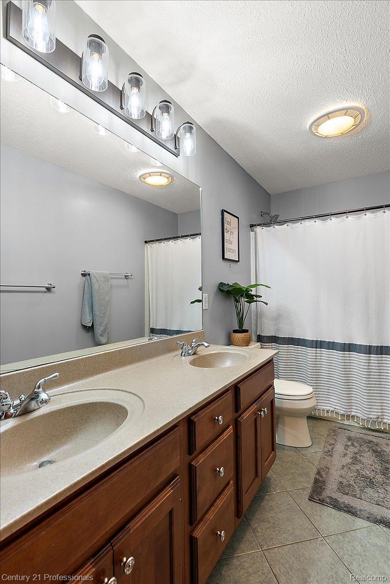 9867 Rainbow Ridge Drive Schoolcraft, MI 49087 - Photo 44 of 82 Double vanity with integrated sinks, wood-finish cabinetry, and brushed nickel hardware