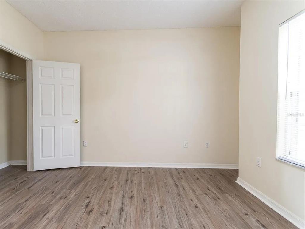 10000 Southwest 52nd Avenue, Unit 99 Gainesville, FL 32608 - Photo 13 of 19 an empty room with wooden floor and windows
