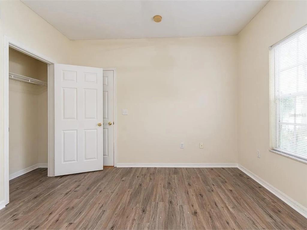 10000 Southwest 52nd Avenue, Unit 99 Gainesville, FL 32608 - Photo 15 of 19 an empty room with wooden floor and windows