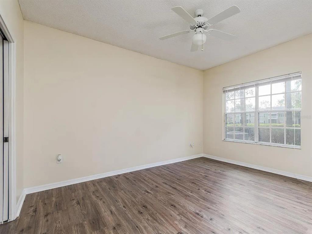 10000 Southwest 52nd Avenue, Unit 99 Gainesville, FL 32608 - Photo 17 of 19 an empty room with wooden floor and windows
