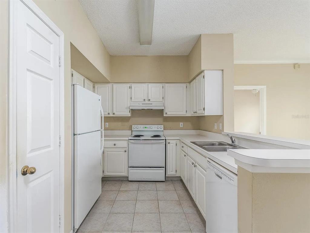 10000 Southwest 52nd Avenue, Unit 99 Gainesville, FL 32608 - Photo 7 of 19 a kitchen with a sink stove and refrigerator