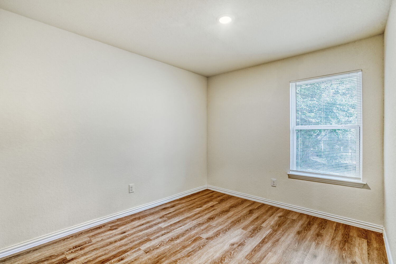 5626 Simsdale Street Houston, TX 77033 - Photo 5 of 10 an empty room with wooden floor and windows