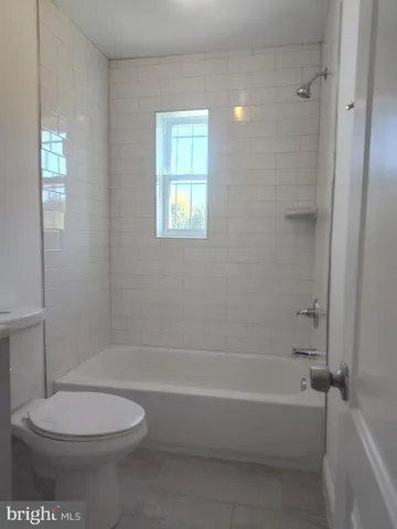 a bathroom with a toilet and a bath tub