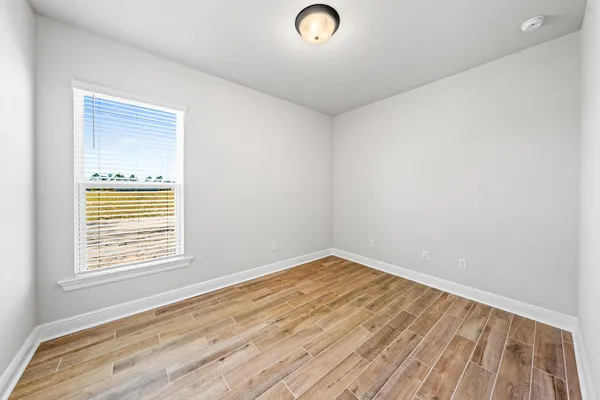a view of a room with wooden floor and window