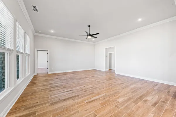 a view of empty room with wooden floor and window