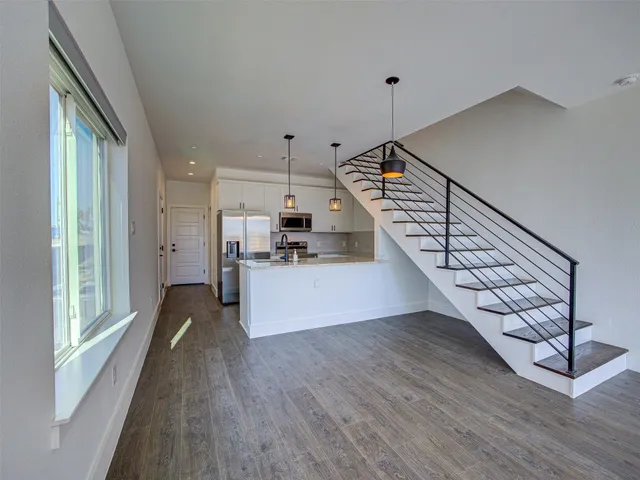 a view of entryway and kitchen with wooden floor