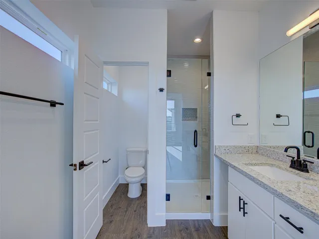 a bathroom with a granite countertop sink mirror and toilet