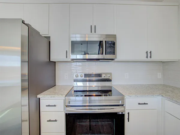 a kitchen with stainless steel appliances granite countertop a stove and a refrigerator