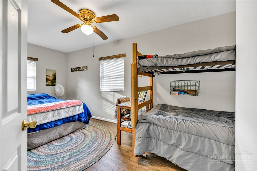 242 Ladd Parson Road Crumpler, NC 28617 - Photo 21 of 36 a bedroom with a bed and a chandelier