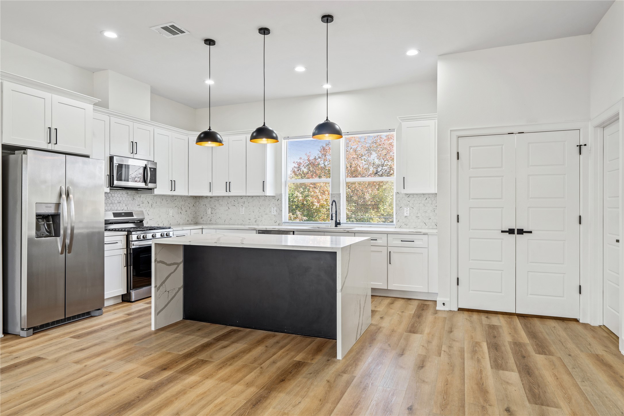 3601 Rebecca Street, Unit A Houston, TX 77021 - Photo 7 of 29 a kitchen with stainless steel appliances granite countertop a refrigerator a oven a sink and white cabinets with wooden floor