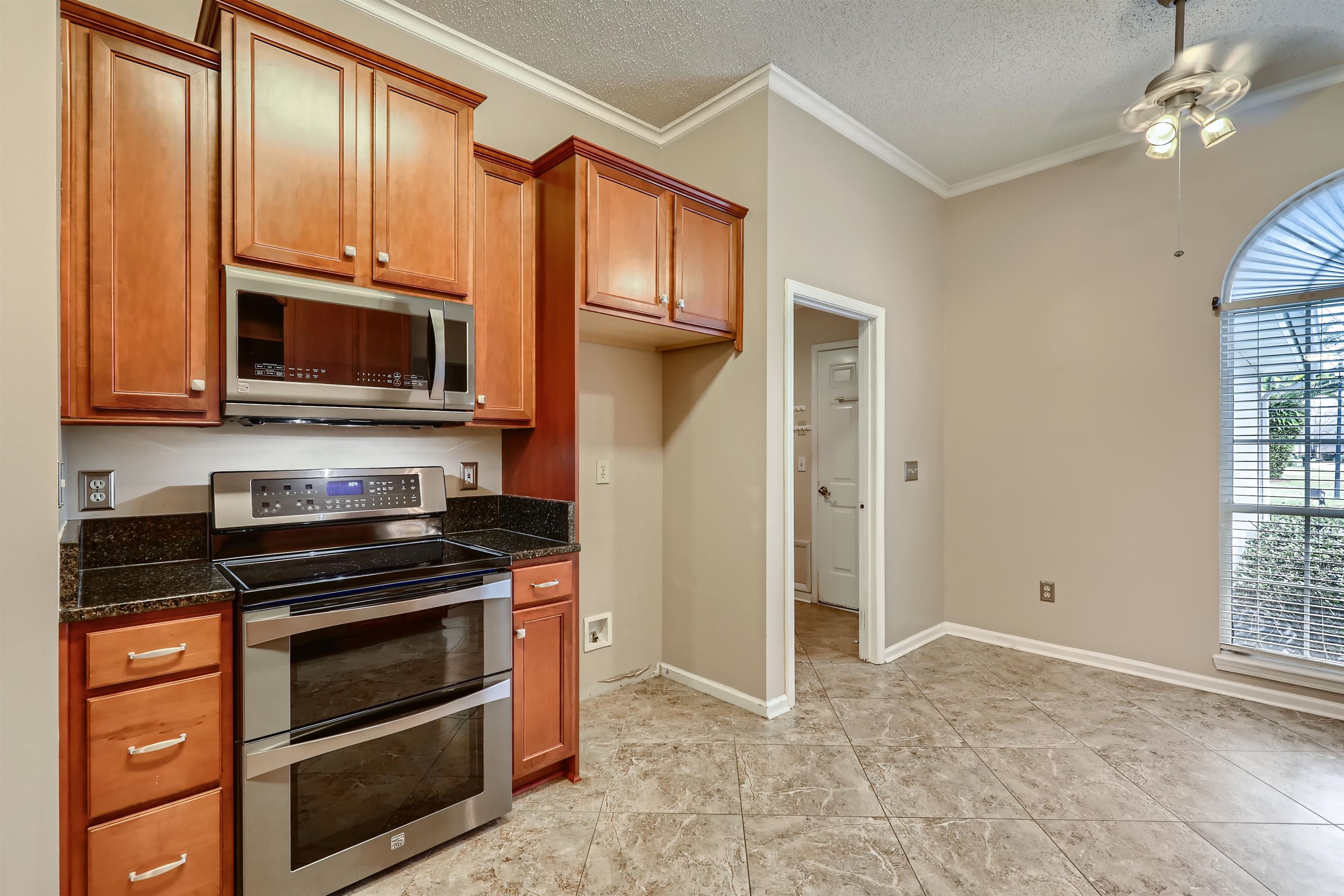3684 Eagle Ridge Drive Jacksonville, FL 32224 - Photo 13 of 33 a kitchen with granite countertop wooden cabinets and a stove top oven