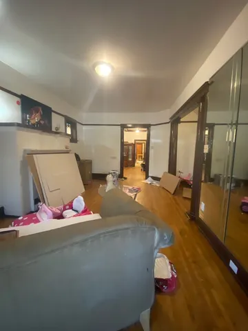 a living room with stainless steel appliances furniture a rug and a kitchen view