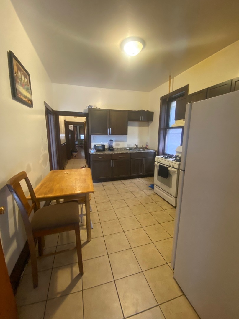 3903 West Monroe Street Chicago, IL 60624 - Photo 4 of 9 a living room with stainless steel appliances furniture a rug and a kitchen view